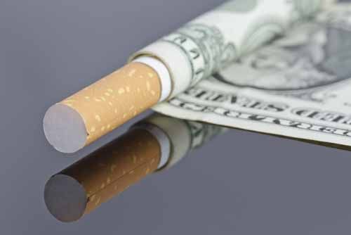 A dollar bill is wrapped around a cigarette